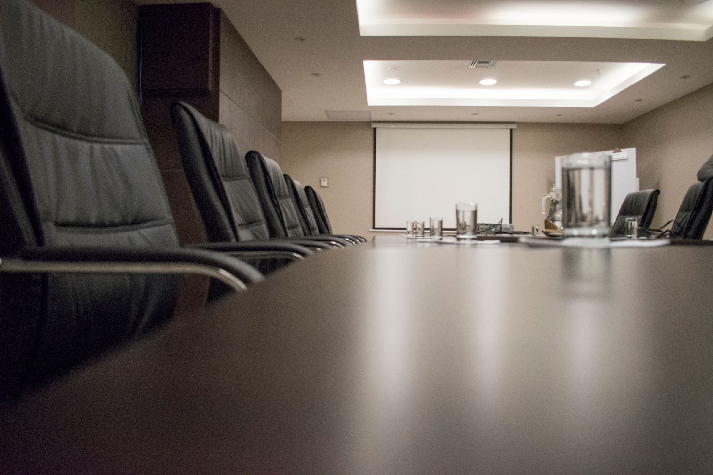 An empty boardroom with leather chairs. Photo: Leandro Alamino / Pexels