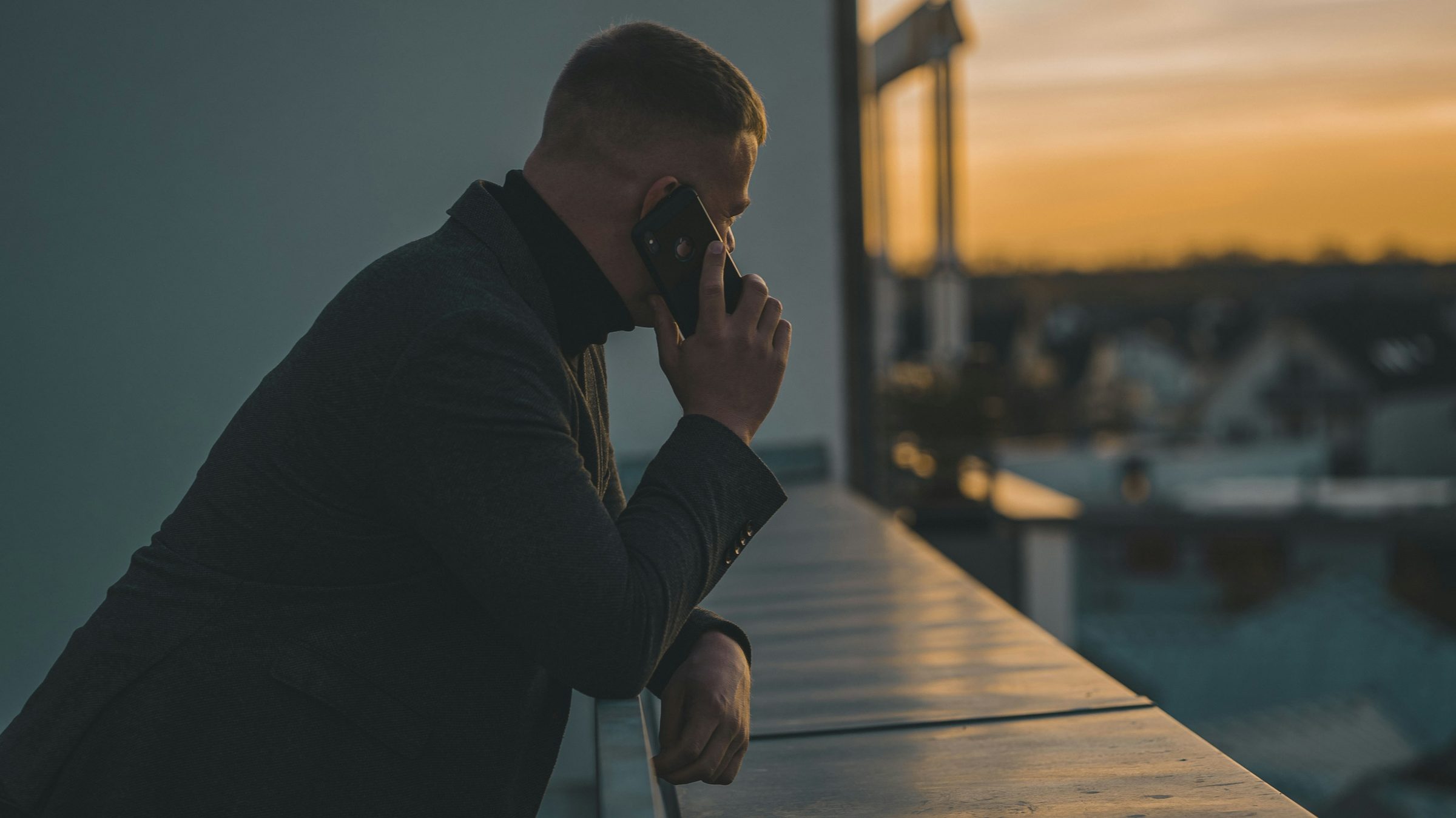 Man on a phone call at a table. Photo: René Ranisch / Unsplash