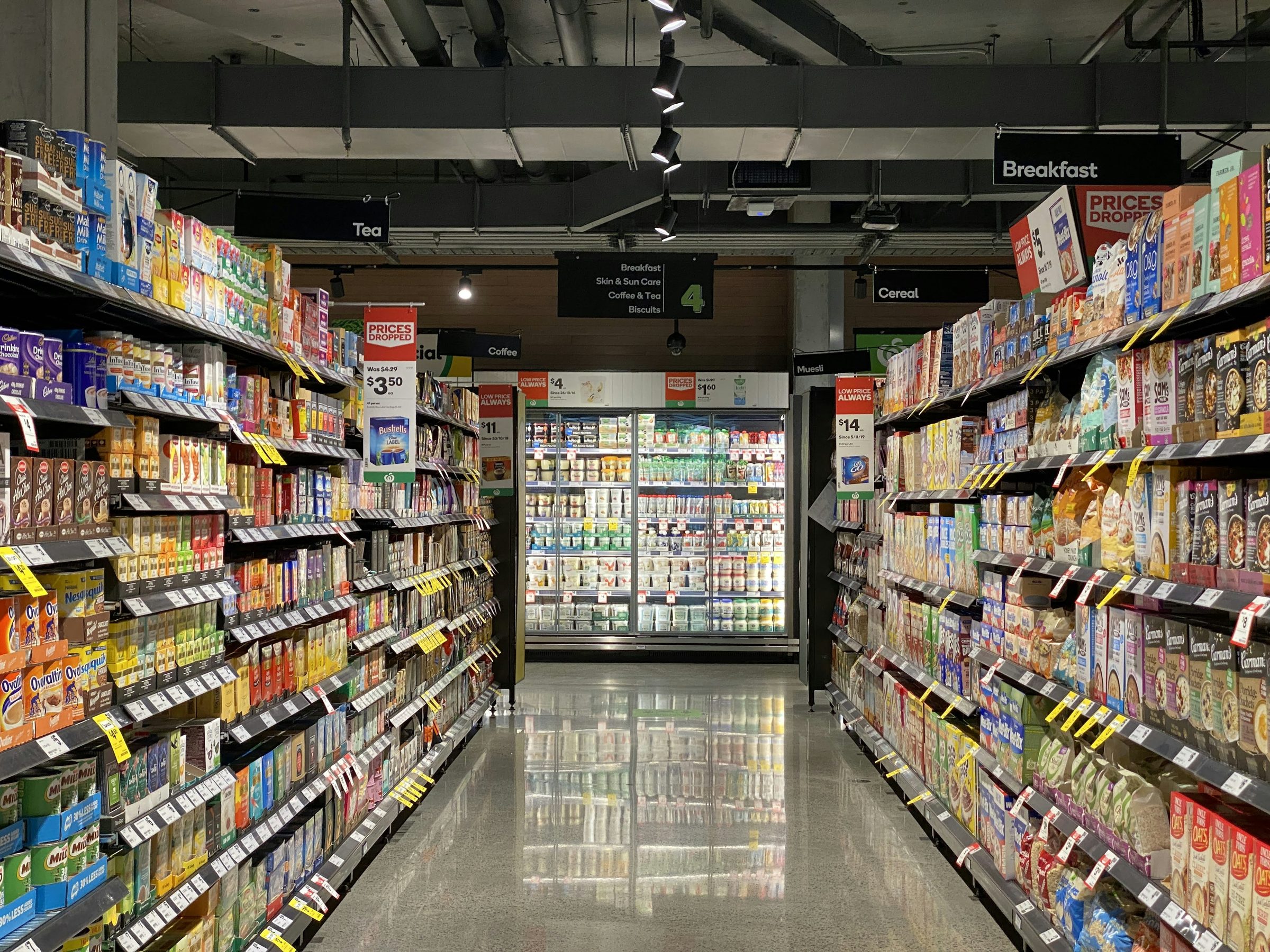 Grocery store aisle with stocked shelves. Photo: Franki Chamaki / Unsplash