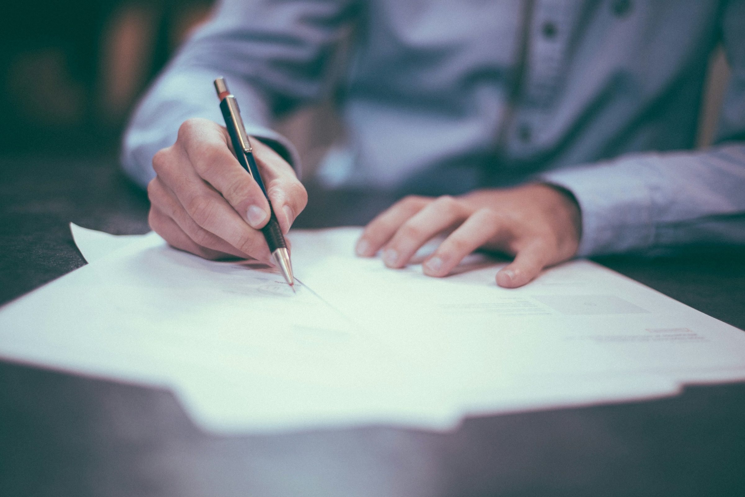 Signing a policy document. Photo: Scott Graham / Unsplash