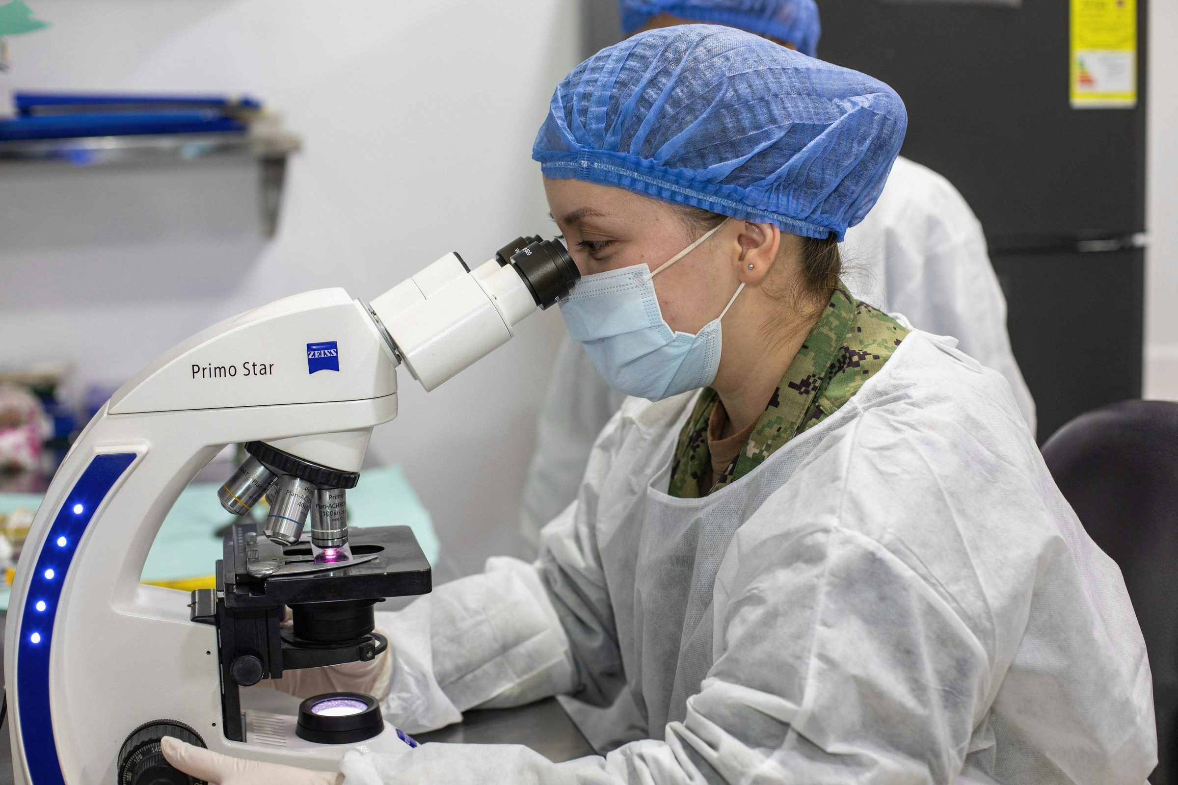 Scientist at a microscope in a laboratory. Photo: Navy Medicine / Unsplash